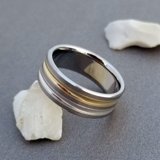 Handcrafted titanium ring with two concave Inlays of solid 18k gold and sterling silver